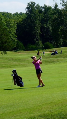 Lewis watches her ball after taking a swing.