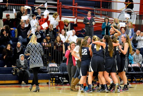 Players and coaches celebrate after Lohr scores her 1000th career point, in a game against Governor Thomas Johnson High School.