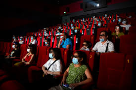 People social distancing with masks while watching a movie. 