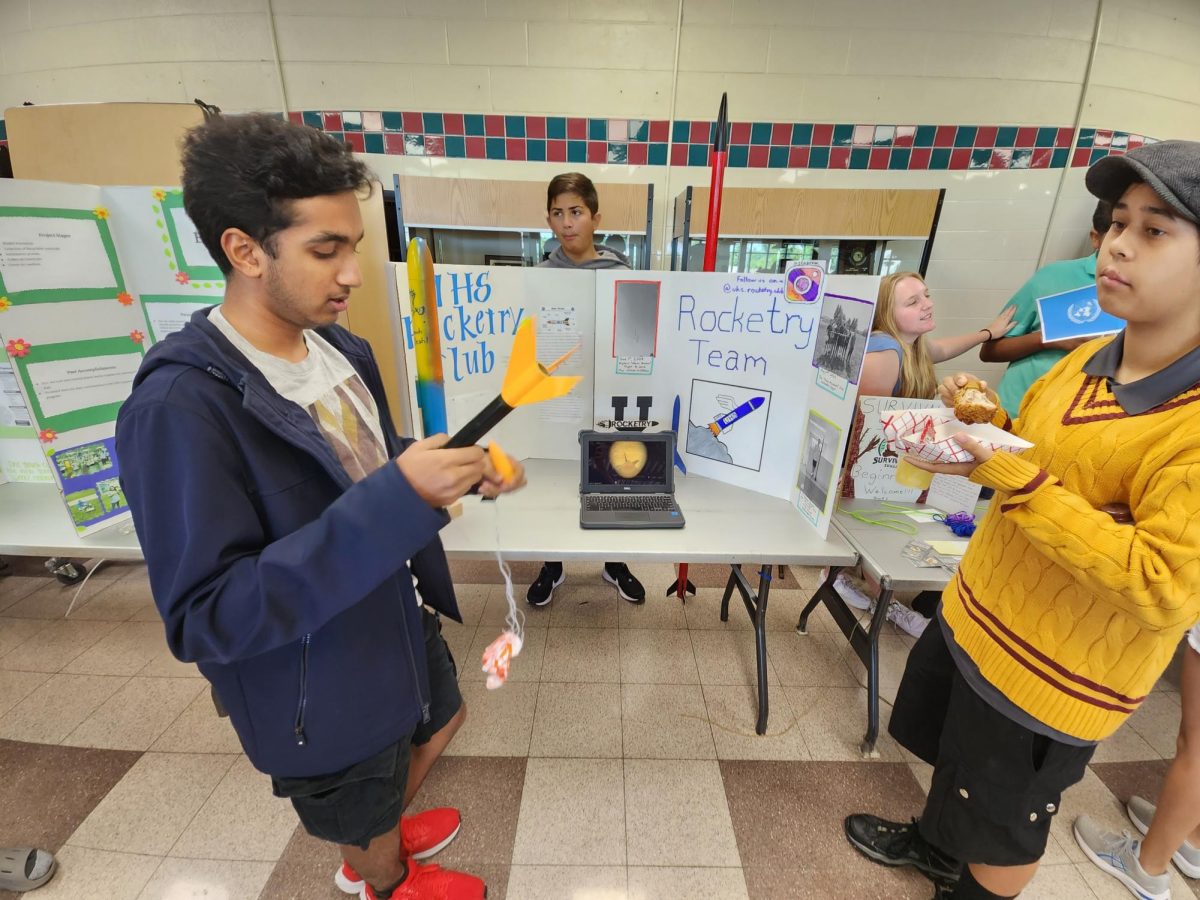 Rocketry Club member Rohil Cheepala talking to student Zachary Phipps about club information.