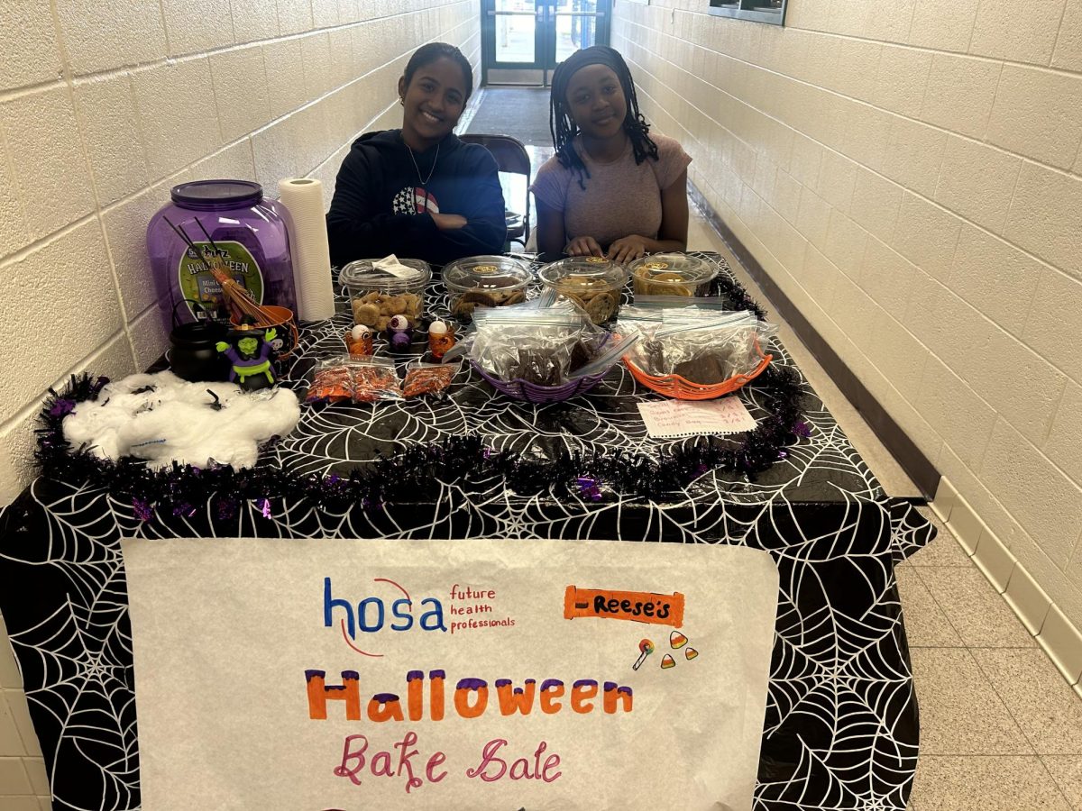 Felicia Siewe (Class of 2025) and Zahrah Shameer (Class of 2027) of the HOSA club work the bake sale during second lunch!