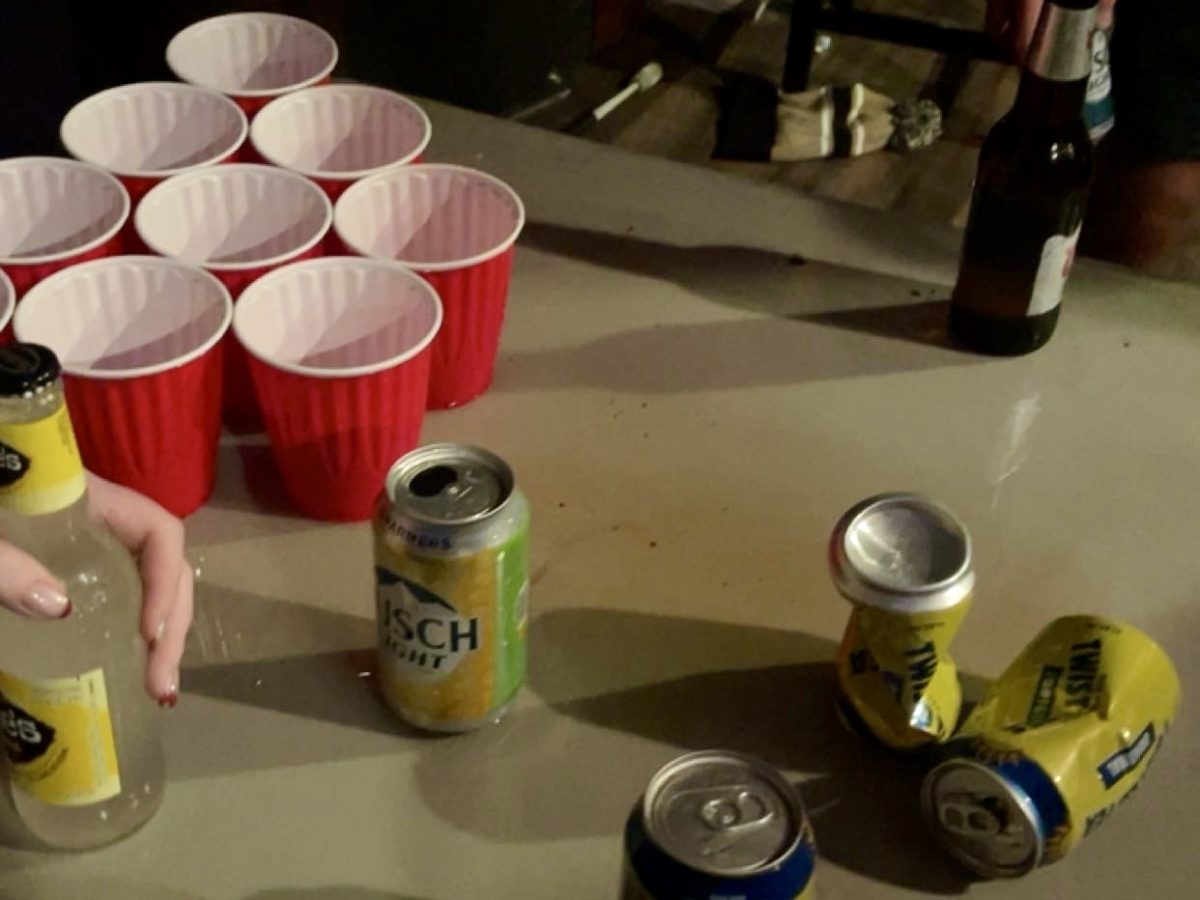 Photo taken at a house party shows empty cans and spilled alcohol.