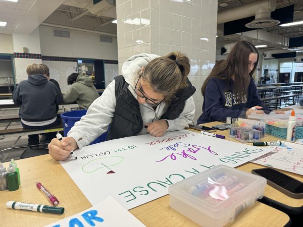 Charley Mcgee works on a poster for the Swing for a Cause bake sale to support the Special Olympics.