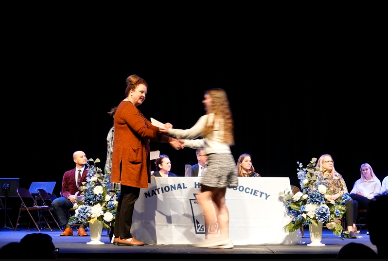 Natalie Suthard accepts her several National Honors Society achievements, including the Math and Spanish Honors Society recognition. She is supported warmly by Principal Donna Clabaugh.