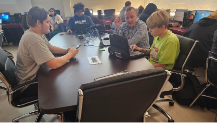 Mr. Frush's new desk has plenty of room for him to help Jimmy Schartner on the computer while Alfred Lackner works on a calculator (not a cell phone).