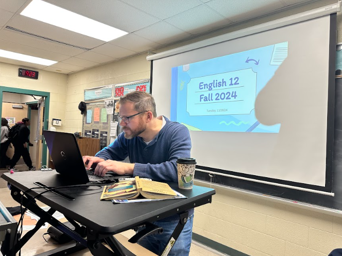 English Teacher Mr. David Lewis grades assignments that students submitted just in time for midterm.