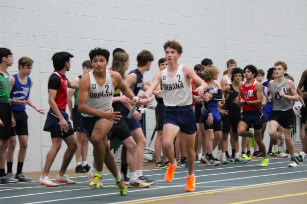 Ethan Reyes (Class of 2025) snatches the baton from Gavin Beidler (Class of 2028) during the 4x800 meter relay at the Terry Baker Invitational.