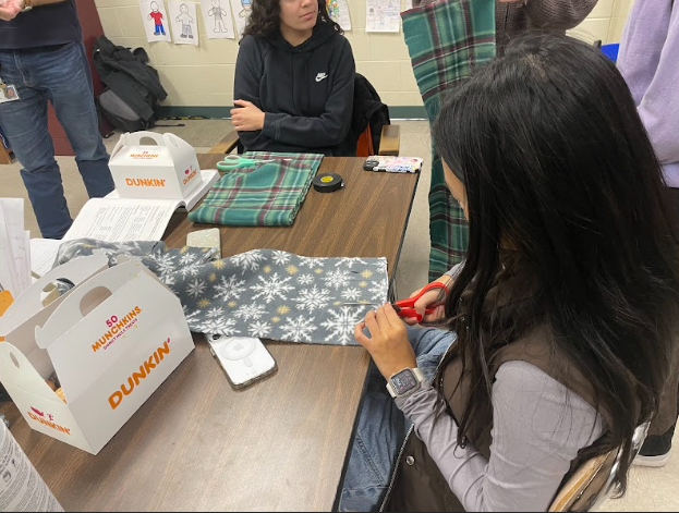 Linhvy Son cuts the fleece to make a scarf. Her contribution will go to the Frederick Rescue Mission and go to someone in need. 