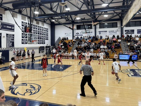 Moses Adoko (#3) takes control, driving the Hawks' offense in the heated matchup.