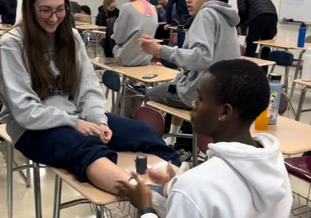 Michael Asante practicing the ankle tape on student. 